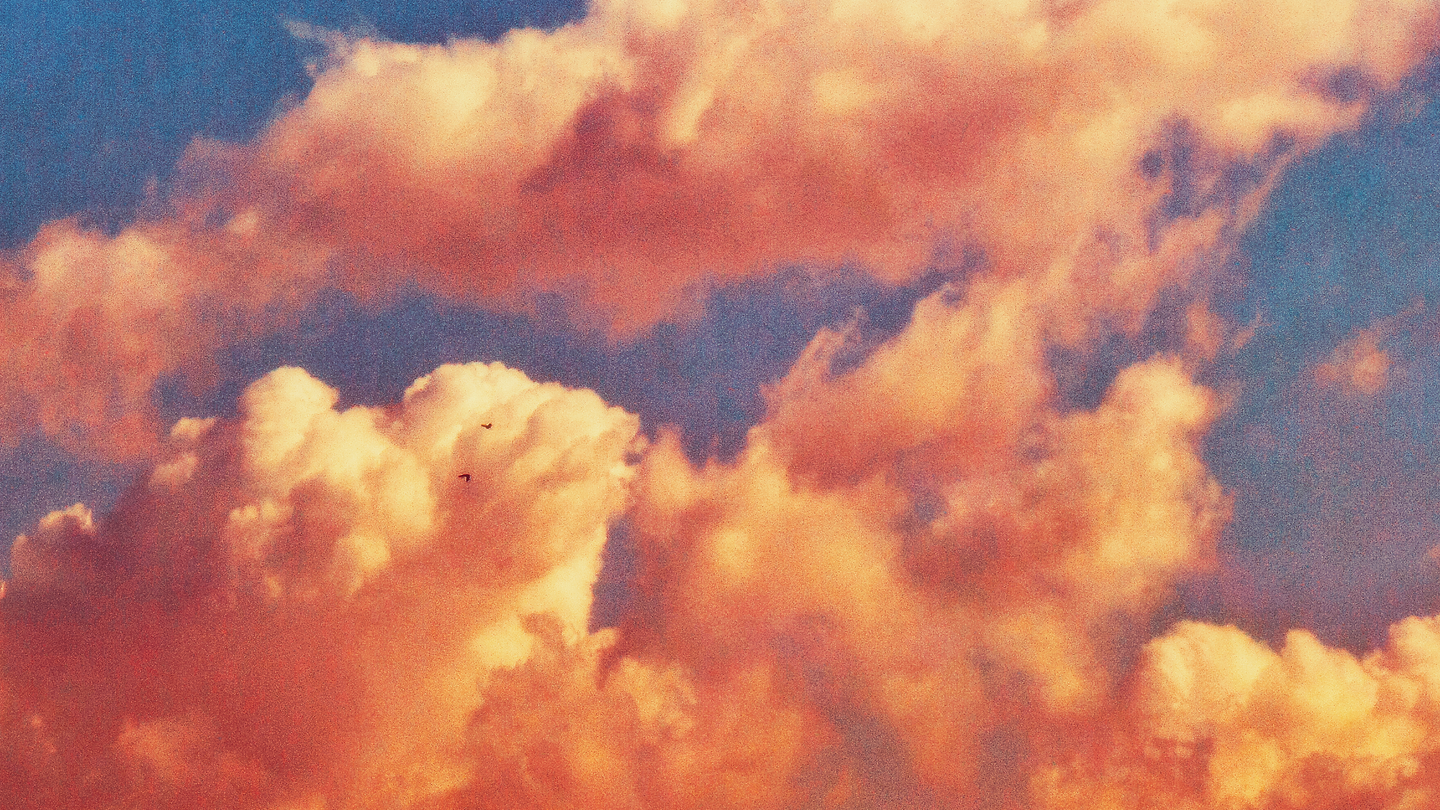Clouds during sunset with two birds flying around